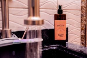 una bottiglia di shampoo seduta su un lavandino del bagno di Makyo Residences a Nairobi Altre 101 foto