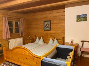 a bedroom with a bed in a wooden room at Berg-Panorama-Ferienwohnungen Gut-Lichtenau in Hauzenberg