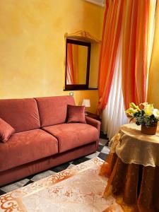 a living room with a red couch and a table at La Poesia Apartment in Monterosso al Mare