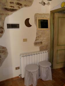 a room with two stools in front of a wall at Appartamenti turistici Vicolo S. Chiara in Sassoferrato