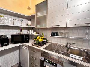 a kitchen with a sink and a microwave at La Poesia Apartment in Monterosso al Mare +14 photos