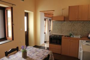 a kitchen with a table and a stove top oven at Main square apartment in Symi