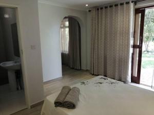 En eller flere senge i et værelse på Musasa gardens