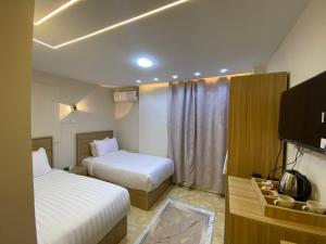 a hotel room with two beds and a television at Isis Pyramids View Inn in Cairo