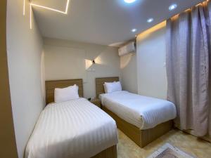 two beds in a small room with a window at Isis Pyramids View Inn in Cairo