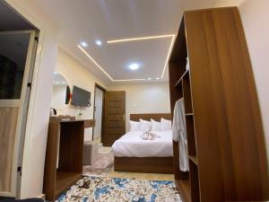 a bedroom with a bed and a desk and a television at Isis Pyramids View Inn in Cairo