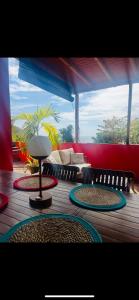 a wooden deck with a table with rugs on it at Villa Victoria in Bouillante