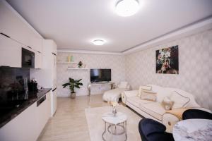 a living room with a couch and a tv at White Home Luxury in Nyíregyháza