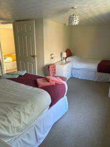 a bedroom with two beds and a sink and a lamp at Miller's Cottage in Woolfardisworthy +19 photos