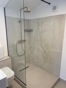 a glass shower in a bathroom with a toilet at Happy apartment 2 in Chiajna