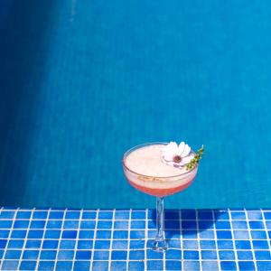a cocktail with a flower on a blue tiled counter at Spektr Boutique Hotel Yalikavak in Yalıkavak