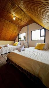 two beds in a room with two windows at La cabaña de la abuela in Sutatausa
