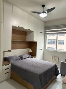 Un dormitorio con una cama y un ventilador de techo. en Aconchego Constante, en Río de Janeiro