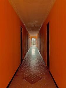 an empty hallway with orange walls and a long corridor at Royal Court Hotel in Kilindoni