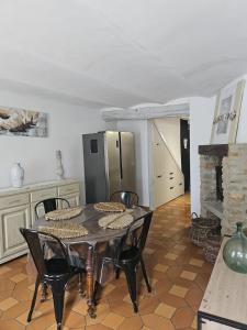 a kitchen with a table and chairs and a refrigerator at 11 Remparts in Malaucène