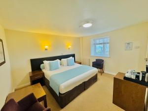 a hotel room with a bed and a chair at The White House Hotel in Herm +117 photos