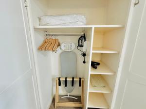 a small closet with white shelves and a door at The White House Hotel in Herm