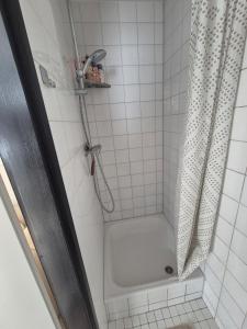 Un baño con ducha con cortina de ducha. en Vlier aan zee, en Katwijk aan Zee 1 foto más