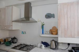 a kitchen with a stove top oven and a sink at Flat One Harbour Street in Whitstable