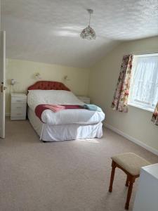 a bedroom with a large bed and a window at Rosie's cottage in Woolfardisworthy +20 photos