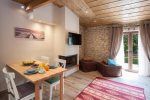 a living room with a wooden table and a television at Anita Village in Perama