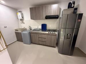 a small kitchen with a refrigerator and a sink at APARTIESTUDIO AMOBLADO SOTOMAYOR ALQUILER RENTA HOUSe in Bucaramanga