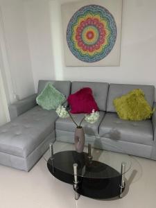 a living room with a gray couch with colorful pillows at APARTIESTUDIO AMOBLADO SOTOMAYOR ALQUILER RENTA HOUSe in Bucaramanga