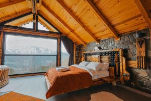 a bedroom with a bed in a room with a stone wall at Avida Bungalov in Çamlıhemşin