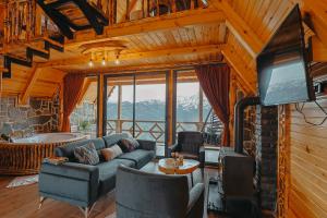 a living room with a couch and a tv at Avida Bungalov in Çamlıhemşin