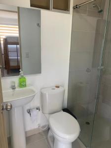 a bathroom with a toilet and a glass shower at Hermoso apartamento con Piscina cerca al Parque Tayrona y Minca in Santa Marta +18 photos