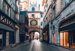 un edificio con una torre de reloj en medio de una calle en Le secret de Saint-Maur, en Rouen