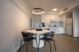 埃拉特Valencia Apartment - By Harim的房间里有一张桌子和几把椅子的厨房