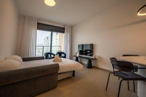 埃拉特Valencia Apartment - By Harim的一间配有床、沙发和桌子的酒店房间 更多12张照片