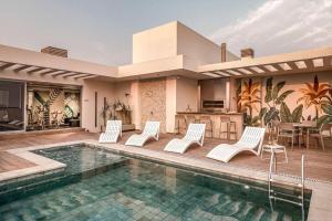 Una casa con piscina con sillas blancas y cocina. en 702 HOUZE Dreamed Place, en Asunción
