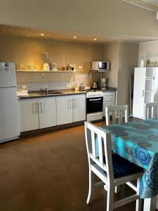 a kitchen with white cabinets and a table with chairs at Chacras del Mar 4x4 in Mar Azul