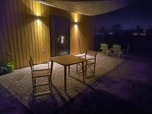 a table and chairs on a patio at night at Natuurhuisje 't Hoogbos - Weidezicht in Schijf