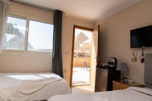een hotelkamer met uitzicht op de piramides bij Tamara Pyramids View in Caïro