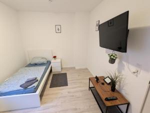 a bedroom with a bed and a flat screen tv at Moderne Wohnung im Erdgeschoss mit Terrasse I ruhige Umgebung in Bremerhaven