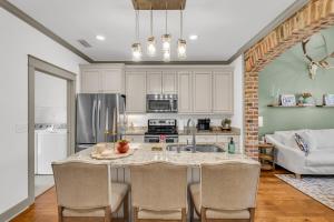 a kitchen with a table with chairs and a kitchen with a couch at Cowbell Cottage in Starkville