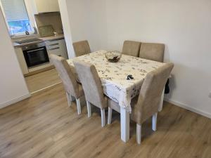 a dining room table with chairs and a table and a kitchen at Relje krilatice in Novi Pazar