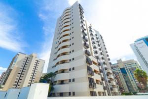 a tall white apartment building in a city at Ozped Private Flats Comfort Suites in Brasília
