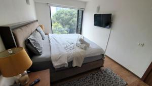 メキシコシティにあるCondominio Villalongin 196の窓付きのベッドがある小さな寝室