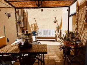 d'une terrasse avec une table, des chaises et un banc. dans l'établissement Cabanon dans la calanque de la Vesse, à Le Rove