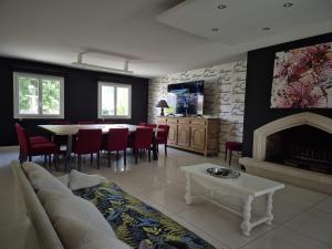 un soggiorno con divano, tavolo e camino di Maison de la villa à la fosse à l'âne 5 chambres a Le Fuilet