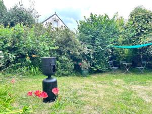 a black bird feeder in a yard with flowers at studio cozy avec jardin privé in Loscouët-sur-Meu +2 photos