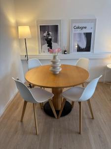 Una mesa de comedor con sillas y un jarrón encima. en Great Location Airport Exhibition Center Downtown, en Düsseldorf