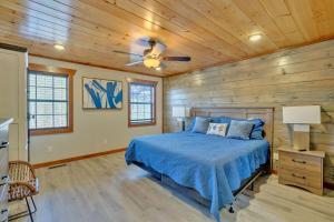 a bedroom with a blue bed and wooden walls at Modern and Cozy 5BR Family Cabin with Private Pool, Hot Tub, Pool Table, Fire Pit & Cozy Mountain Vibes in Sevierville