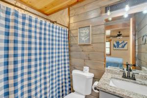 a bathroom with a toilet and a sink at Modern and Cozy 5BR Family Cabin with Private Pool, Hot Tub, Pool Table, Fire Pit & Cozy Mountain Vibes in Sevierville