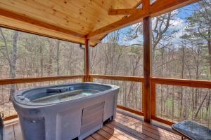 a large tub sitting inside of a screened in porch at Modern and Cozy 5BR Family Cabin with Private Pool, Hot Tub, Pool Table, Fire Pit & Cozy Mountain Vibes in Sevierville