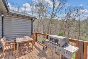 a patio with a grill and a table on a deck at Modern and Cozy 5BR Family Cabin with Private Pool, Hot Tub, Pool Table, Fire Pit & Cozy Mountain Vibes in Sevierville